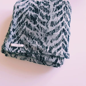 Stickad halsduk från Pieces med zebramönster - Snygg och lång stickad halsduk från Pieces med svartvitt zebramönster. Perfekt accessoar för att lyfta din outfit och hålla dig varm. Mjuk och skön känsla, passar dig som gillar att sticka ut lite extra.  Helt & fint skick