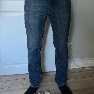 Nudie Jeans blå jeansbyxor 28/30 - Säljer ett par klassiska blå jeans från Nudie Jeans i storlek 28/30. Jeansen har raka ben, snygga kontrastsömmar och ikonisk broderad bakficka. Tillverkade i slitstark bomull med en normal passform och midja.  Priset går att diskuteras. Fraktar inom 1-2 dagar!