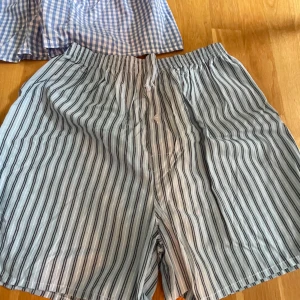 3-pack pyjamasshorts i bomull, M - Tre par pyjamasshorts i mjuk bomull. Ett par är marinblå, ett par har blåvitt rutigt mönster och ett par är blå- och vitrandiga. Alla har elastisk midja och knappgylf. Perfekta för chill dagar!