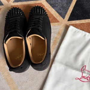 Svarta Christian Louboutin skor med nitar - Säljer ett par svarta Christian Louboutin sneakers med nitar i storlek 43. Skorna är i mycket gott skick. Dustbag medföljer. Perfekt för sommaren!☀️⛱️ Pris: 1599, kan diskuteras vid snabbaffär!