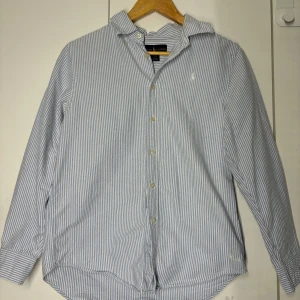 Ralph lauren skjorta - Säljer denna klassiska stilrena skjortan från Ralph lauren. Använd 1 gång bara men kunde inte ha den. Köpt förra året så skicket är 10/10 den är som ny. Storlek Large 14-16 år i barn men passar som xs. Fraktas inom 48 timmar.