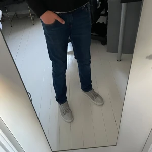 Levi's 511 Slim jeans blå - Säljer ett par klassiska Levi's 511 Slim jeans i blå denim. Byxorna har normal passform med smalare ben, fem fickor och snygga kontrastsömmar. Perfekta för dig som gillar en stilren och tidlös look.