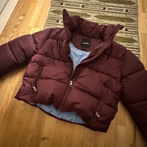Pufferjacka  - Vinröd Pufferjacka som är blå på insidan i storlek M från monki, endast provad. Nypris 800 kr. använd ”köp nu”