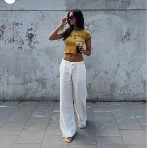 Vita linnebyxor med knytband - Säljer ett par vita linnebyxor med breda ben och knytband i midjan från Alonha. Helt nya, aldrig använda med prislapp kvar.