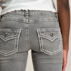 Grå bootcut jeans med kontrastsömmar - Snygga grå jeans med bootcut passform och dekorativa vita kontrastsömmar på bakfickorna. Skickar gärna fler bilder!💕💕