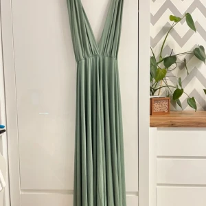 Ljusgrön multiway långklänning från Rose Avenue - Säljer en ljusgrön långklänning från Rose Avenue i multiway-modell som kan knytas på flera olika sätt. Klänningen har djup v-ringning och är ärmlös, tillverkad i ett mjukt och följsamt material. Perfekt för bal eller annan tillställning💕💕