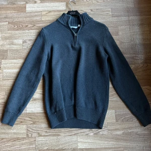 Mörkgrå stickad tröja med zip från Dobber  - Säljer en mörkgrå stickad tröja från Dobber med halv dragkedja och hög krage. Jag köpte den på MQ i Göteborg. Den har inte används så många gånger. Personligen är den lite för lång för min del.