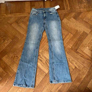 Blå bootcut jeans - Snygga blå bootcut jeans med klassisk femficksdesign. Jeansen har en bekväm passform och är perfekta för en avslappnad stil. De är tillverkade i ett slitstarkt denimtyg.