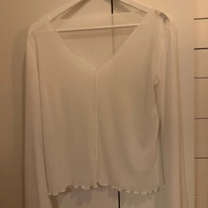 Vit långärmad croppad topp - Säljer denna jätte snygga vita tröjan, som är tunn och man ser lite igenom, vilket är så snyggt. Den är endast använd ett fåtal gånger och i väldigt bra skick. Hör av er vid frågor❣️pris kan diskuteras 