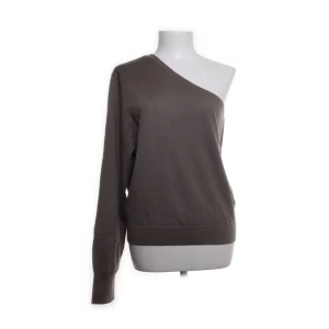 Brun one shoulder-tröja från & Other Stories - Säljer en äkta brun långärmad tröja från & Other Stories med unik one shoulder-design. Tröjan har en avslappnad passform och är tillverkad i mjukt ull, perfekt för en trendig och stilren look.