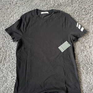 Svart t-shirt från Zadig & Voltaire - Säljer en svart t-shirt från Zadig & Voltaire med vita pilar på ena ärmen. Tillverkad i ett lyxigt material och helt ny!!!!! 
