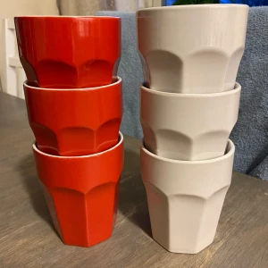 Sex stapelbara muggar i rött och vitt - Säljer sex stycken stapelbara muggar i keramik, tre röda och tre vita. Muggarna har en modern, kantig design med fasetterade sidor och rymmer lagom till kaffe eller te. Perfekta för köket eller fikastunden.