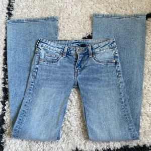 Ljusblå bootcut jeans - Säljer ett par ljusblå lågmidjade bootcut jeans från h&m, midjemått rakt över 35cm innerbensmått 79cm, säljer då de är för små, säljer endast via instabox