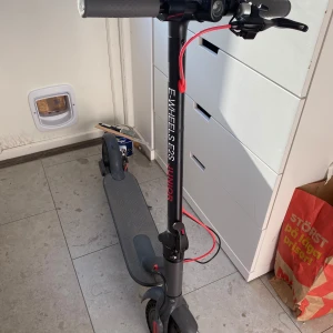 Elsparkcykel E-Wheels E2S Junior - Säljer en svart elsparkcykel E-Wheels E2S Junior. Den har digital display på styret som visar hastighet och batterinivå. Utrustad med handbroms och röd kabeldetalj. Passar perfekt för yngre användare. Ganska använd och batteriet tål inte att köra i direkt kraftig vind vid ramning.