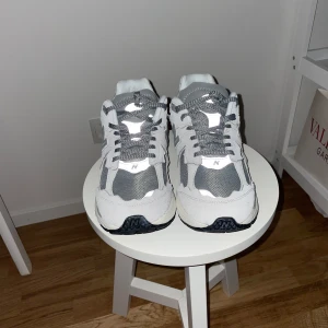 Grå New Balance 2002R  - Säljer ett par grå New Balance 2002R skor. Så här ser du ut med Blixt med annars är lyser de inte lika mycket 