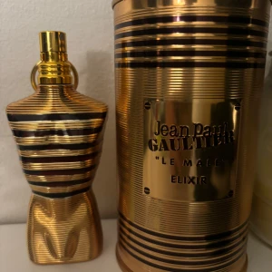 Jean Paul Gaultier Le Male Elixir Eau de Parfum - Lyxig herrparfym i en ikonisk guld- och svartrandig flaska formad som en manlig torso. Kommer i en matchande metallburk med präglad etikett. Doften är intensiv och modern, perfekt för dig som vill sticka ut. Ungefär 60 ml kvar i flaskan 🙌🏼