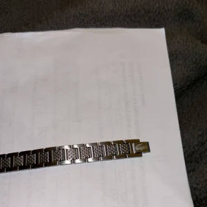 Silverfärgat armband med mönstrade länkar - Säljer ett stilrent armband i silverfärg med rektangulära länkar. Bättre att det kommer till användning än att den samlar damm här pris kan diskuteras vid snabb och smidig affär