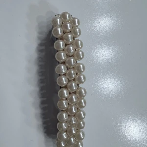 Hårspänne med pärlor - Stilrent hårspänne dekorerat med vita pärlor i två rader. Perfekt accessoar för att ge frisyren en elegant touch. Metallspänne på baksidan för enkel användning.