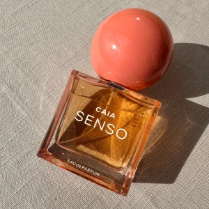 Caia Senso Parfym  - Mjuk men samtidigt kraftfull karaktär är Senso som en vårserenad; en blommig gourmand-blandning av mandarin, röda vinbär och orientaliska noter. Den öppnar upp sig till ett kraftfullt hjärta där friska blommor balanseras av plommons djup. Driven av en varm underton av patchouli, amber och mysk, är den skapad för att hålla långt förbi solnedgången. Toppnoter: Mandarin, kryddor, röda vinbär och grönt  Hjärtnoter: Plommon, ros, fresia och apelsinblom  Basnoter: Bärnsten, patchouli, mysk och gourman