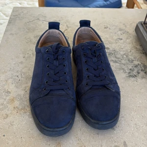 Mörkblå loubs sneakers i mocka - Säljer ett par mörkblå loubs utan spikar.Storlek 40 men passar 41. Knappen är lite av vid snörena. De är i bra skick. Dock har jag inte boxen