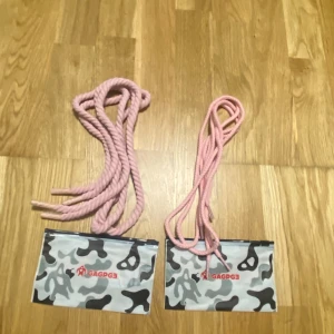 Rosa skosnöre från GAGPG3 - Säljer rosa skor snöre från GAGPG3. Bältet är gjort av ett tjockt, tvinnat rep och kommer i en förvaringspåse med kamouflagemönster. Perfekt accessoar för dig som vill sticka ut med en unik stil.