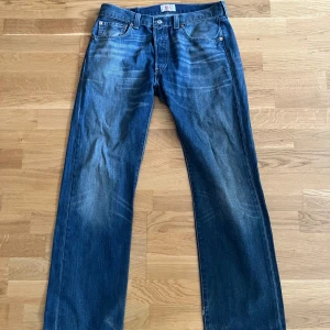 Levi’s 501 Jeans - Ett par Levi’s Jeans i en skit snygg blå färg som har en straightleg passform. Jeansen lite slitna längst ner vid bena men är annars i mycket bra skick utan några fläckar eller skador. Om du undrar något om plagget är det bara att skriva!