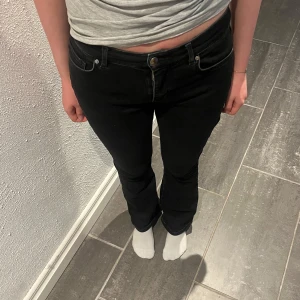 Svarta low flare jeans - Svarta jeans med låg midja och flare-ben. Klassisk femficksmodell med knapp och dragkedja framtill. Snygga och enkla att matcha till olika outfits. Längd 31. Hör av er vid kommande frågor eller fler bilder.💛