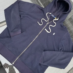 Mörkblå Hoodie från Polo Ralph Lauren - Tjena! Säljer en fet Mörkblå Hoodie som kan vara bra för kallare Sommarkvällar. Hör av er vid frågor! Tröjan är Strl M. Pris kan diskuteras vid snabb affär