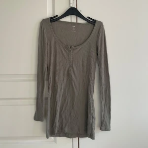 Grå tröja från HM - Längre tröja med knappar fram från HM. Ganska använd, slitage på knapparna och tröjan är lite nopprig som knappast syns. 