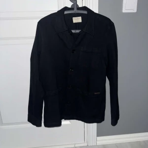 Nudie Jeans Overshirt Svart - Svart Overshirt från Nudie Jeans i storlek S, men sitter även bra på dig som har M. Använd fåtal gånger – i princip som ny! Snygg och stilren modell i slitstarkt material, passar perfekt som jacka på våren eller lager på lager under höst/vinter.