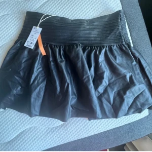 Svart kjol Gina Tricot - Säljer en svart kort kjol från Gina Tricot i skinnimitation. Kjolen är storlek 158/164 men skulle säga xs-s🩷 aldrig använd, endast testad, därav helt nyskick🩷lappen är dock inte kvar🩷