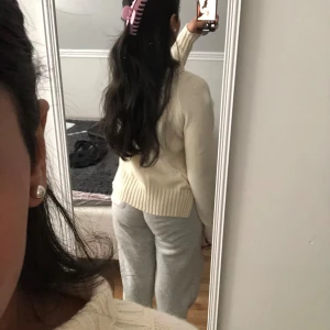 Krämvit stickad tröja - Mysig krämvit stickad tröja med rund hals och ribbade muddar vid ärmslut och nederkant. Tröjan har en klassisk passform och är perfekt för kyligare dagar. Säljer då jag inte använder längre. Användt den minst 2 ggr. 