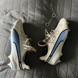 Puma king Fotbollsskor SG  - Säljer ett par vita puma king SG skor där FG dobbar medföljer. Använt skorna en halv säsong men lagt av med fotbollen nu och de tar bara plats.
