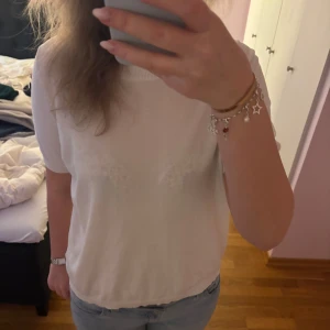 Vit kortärmad topp - Säljer en enkel och stilren vit topp med korta ärmar. Toppen har en rund halsringning och är tillverkad i ett mjukt material som passar perfekt till vardags. Lätt att matcha med jeans eller kjol.