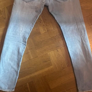 Ljusblå Replay jeansbyxor herr W32 L32 - Säljer ett par ljusblå jeans från Replay i modellen 550. Klassisk femficksdesign, raka ben och röda detaljer vid midjan. Jeansen har normal passform och är i storlek W32 L32. 