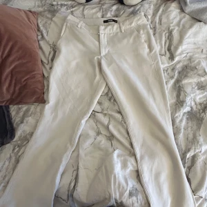 Beiga bootcut kostymbyxor - Snygga vita kostymbyxor med bootcut-passform. Sedna har den slits längst ner vid benen jätte snygga har tyvärr blivit försmå för mig. Sista bilden ser ni en defekt men inte synlig när man dem på sig knappast!! Inget man tänker på eftersom den är längst ner på benet 