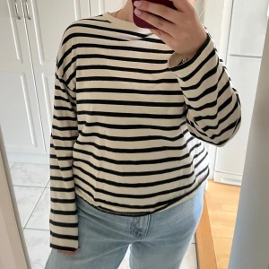 Randig tröja från Pull&Bear - Säljer en snygg randig tröja från Pull&Bear i svart och vit. Tröjan har långa ärmar och en klassisk rund halsringning. Perfekt för en stilren look.
