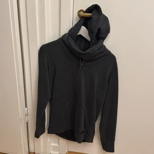 Mörkgrå hoodie från Diesel - Säljer en mörkgrå hoodie från Diesel med stor huva och dragsko. Tröjan har en känguruficka framtill och är tillverkad i mjukt material. Perfekt för en avslappnad stil. Storlek M.