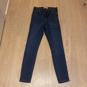 Blå skinny jeans Molly från Gina Tricot - Säljer ett par klassiska blå skinny jeans från Gina Tricot, modell Molly. Jeansen har hög midja, fem fickor och stängs med dragkedja och knapp. Perfekta till vardags och enkla att matcha med olika toppar. Blivit använda 1 gg.