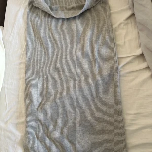 Ljusgrå ribbad kjol - Säljer en ljusgrå ribbad kjol med tight passform. Har en enkel, stilren design som passar perfekt till sommaren. Materialet är mjukt och stretchigt för en bekväm känsla.