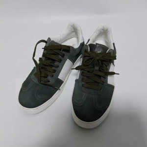 Valentino Garavani flycrew | byte - Snygga sneakers från Valentino Garavani i grönt mocka och vitt skinn. Skorna har gröna snören, vita detaljer och nitar på sidan av sulan. Kan bytas mot förslag eller säljas för summan som angett kartong eller kvitto finns ej