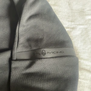 Svart jacka från Sail Racing - Säljer en svart jacka från Sail Racing med dragkedja framtill och två fickor med dragkedja. Jackan har hög krage och en stilren design, perfekt för dig som gillar sportig stil.