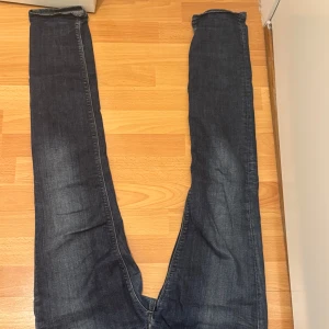 Mörkblå Replay jeansbyxor Anbass - Säljer ett par mörkblå jeansbyxor från Replay, modell Anbass. Byxorna har klassisk femficksdesign, dragkedjegylf och raka ben. Snygga slitningar framtill och bakfickor med diskreta sömmar. Perfekta för en avslappnad stil.