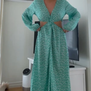 Grön trendig hm klänning med cut-out - Säljer denna jättesnygga gröna långklänning med v-rigning och cut-out, då jag har två💚den (som jag säljer) är endast testad, men utan prislapp!! Bud ligger på 600kr, köp direkt för 750kr🥰