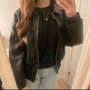 Svart skinnjacka från Bershka - Snygg svart skinnjacka från Bershka med dragkedja framtill. Jag köpte den här jackan på Vinted, men jag tyckte inte riktigt att det var min stil, så jag väljer att sälja den vidare. Inga defekter. Skriv gärna om du har fler frågor, pris kan diskuteras!