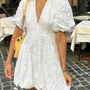 Vit klänning med puffärmar - Säljer en söt vit klänning med puffiga kortärmar och v-ringad hals. Klänningen har ett vackert broderat mönster och en kort längd som ger en lekfull look. Perfekt till studenten!🥰bara testad så aldrig använd!
