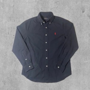 Polo ralph lauren skjorta - En ny polo ralph lauren skjorta i bra skick den är mörkblå med röd detalj, knappar, storlek S skulle säga den passar 170-175 🙌 fråga om ni har frågor !!