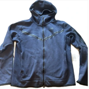 Blå fleecejacka från Nike - Säljer en mörkblå nike tech, köptes i Stockholm för ungefär 2 år sen tröjan är i bra skit och har ej några skador. Hör gärna av er vid frågor 