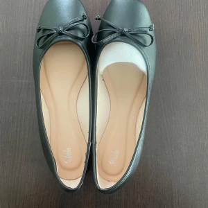 Svarta ballerinaskor med rosett - Eleganta svarta ballerinaskor från Shein med en söt rosett på ovansidan. Aldrig använda då det var för stora!pris kan diskuteras😊