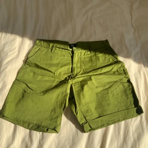 Gröna shorts med knappar - Snygga gröna shorts med knappar och fickor fram. Perfekta för en avslappnad stil under varma dagar. De har en klassisk passform och är gjorda i ett bekvämt material.